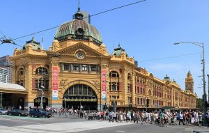 Facade of Flinders Street Station, Melbourne with lots of people crossing the road to and from the train station.