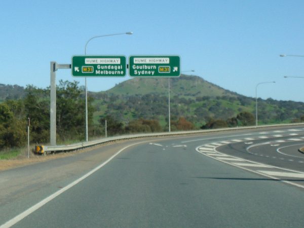 Two signs on the Hume Highway advising go left to Melbourne and right to Sydney.