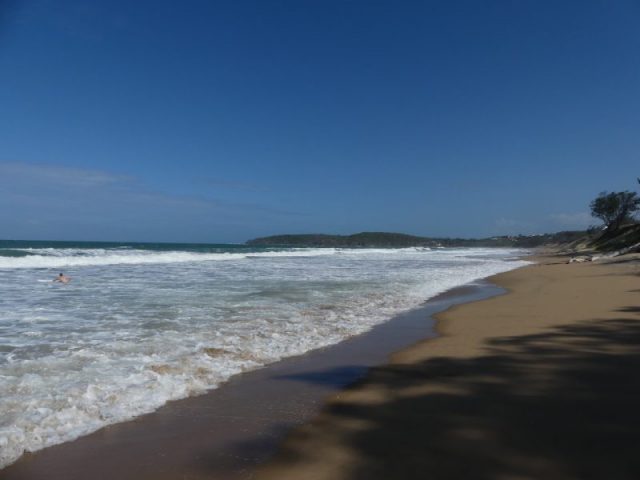 Agnes Waters Beach. White Sandy Beach With Waves Rolling Over The Shore.
