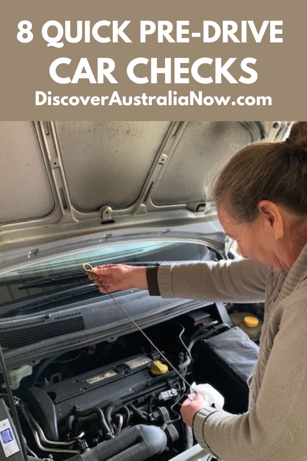 Car checks. Female with bonnet of car up checking the oil of a car's engine.