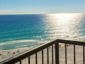 Room with a view overlooking white sand and blue ocean.