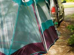 silver car and a greenish tent used car camping.