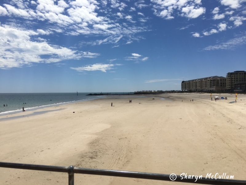 white sand lapped by small waves at Glenelg Beach.