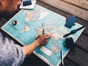 person with a map plotting their Australian travels to make life cheaper geoarbitrage Australia.