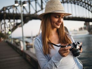 Female with a camera taking photos of Sydney Harbour.