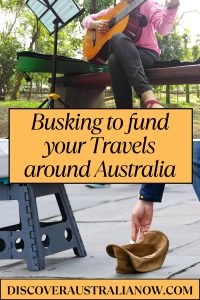 a female busking playing guitar and someone putting money in her hat.