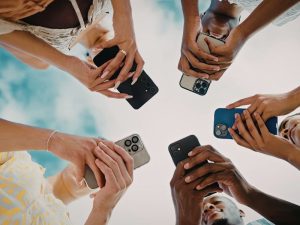 5 people with phones checking emergency warnings